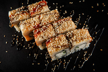 top view closeup philadelphia roll sushi with eel cucumber, cream cheese and sesame seeds on top