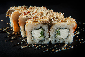 closeup philadelphia roll sushi with eel cucumber, cream cheese and sesame seeds on top