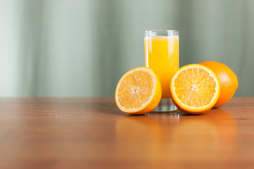glass of fresh orange juice with fresh fruits on wooden table