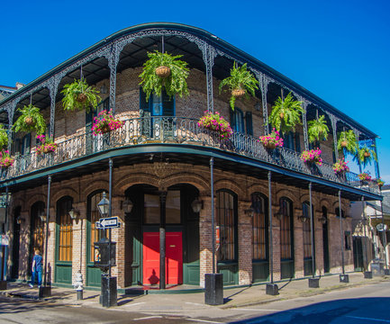 French Quarter architecture in New Orleans, Louisiana. House in French Quarter in 18th century Spanish style with cast iron galleries with hanging plants and pastel colors. 