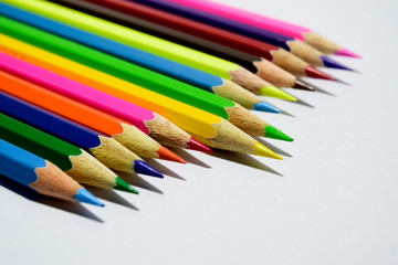 Multiple colored pencils on a white background.