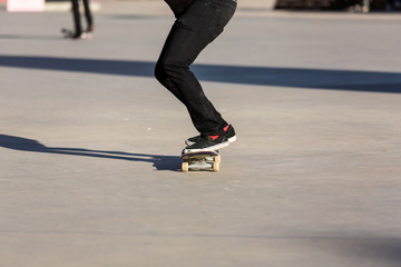 Fototapeta na wymiar Person riding a skate board in an urban asphalt park