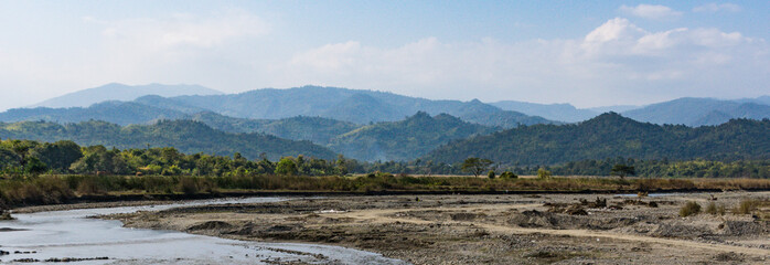 banner landscape of river curving  through the countryside with mountains in the background in Mandalay District, Myanmar