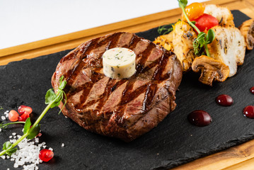 grilled Medium rare barbecue steak Ribeye with herb butter on cutting board