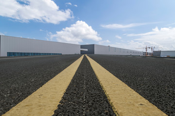 Road asphalt pavement and modern factory warehouse..