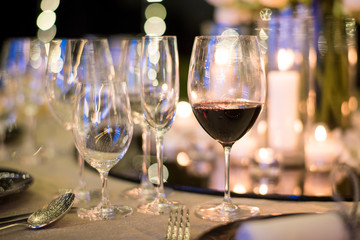 Beautiful wedding table setting decor with glasses of red wine.