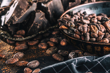Dark chokolate cocoa beans and powder on concrete table