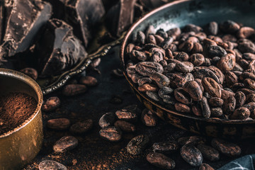 Dark chokolate cocoa beans and powder on concrete table
