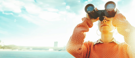 Beautiful Young Girl Looking Through Binoculars At The Sea On A Bright Sunny Day. Travel Holidays Journey Concept