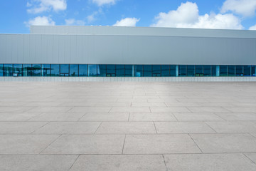 Empty square floor tiles and modern factory buildings and warehouses..