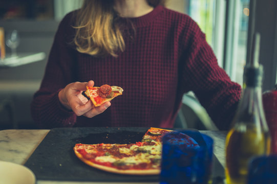 Young woman eating pizza