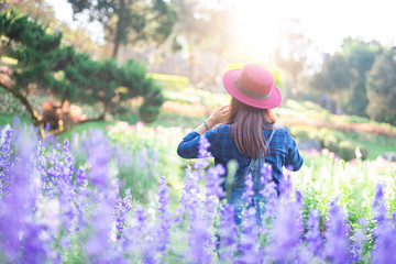 Young women and flower care in the garden that are blooming in the morning