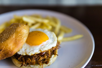 Pull Pork burger With French Fries on the white plate.