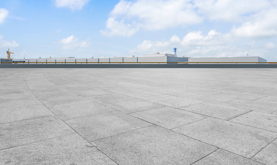 Empty square floor tiles and modern factory buildings and warehouses..