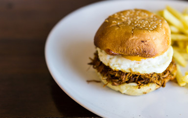Pull Pork burger With French Fries on the white plate.