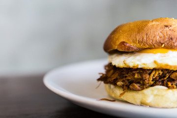 Pull Pork burger With French Fries on the white plate.