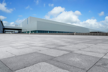 Empty square floor tiles and modern factory buildings and warehouses..