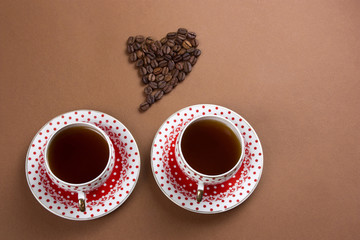 top view black coffee cups and heart made from coffee beans brown background