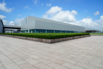 Empty square floor tiles and modern factory buildings and warehouses..