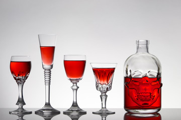 A skull bottle and crystal glasses with a liquid, alcohol drink.