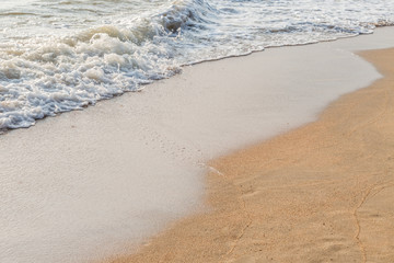 White water wave of the sea on the sandy beach