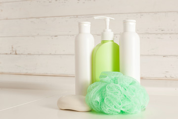 Bath accessories. Shampoo, balm tubes on neutral background. Skin care products. Toiletries on wooden background with copy space. Women cosmetic for shower.