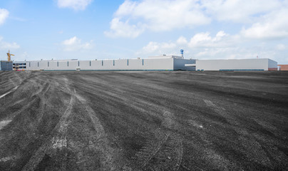 Road asphalt pavement and modern factory warehouse..