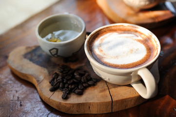 Cappuccino coffee in white cup and cup of tea lay on tray wooden on the table,Relax time with coffee,Art of coffee