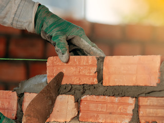 Construction worker installing bricks in construction site