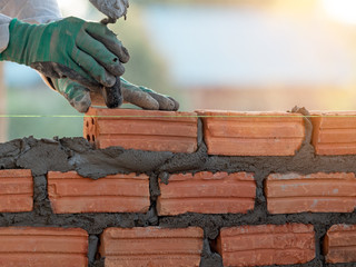 professional construction worker laying bricks in new industrial site