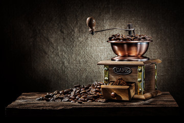 coffee mill with beans on vintage wood
