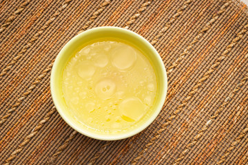 Bowl of chicken broth on rural table