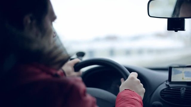 A man gets into the car and turns on the navigator on the smartphone