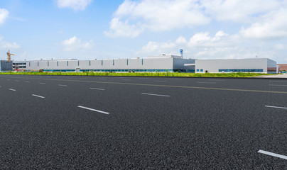 Road asphalt pavement and modern factory warehouse..