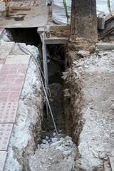 Fototapeta na wymiar Open trench under pavement with electrical and internet wires