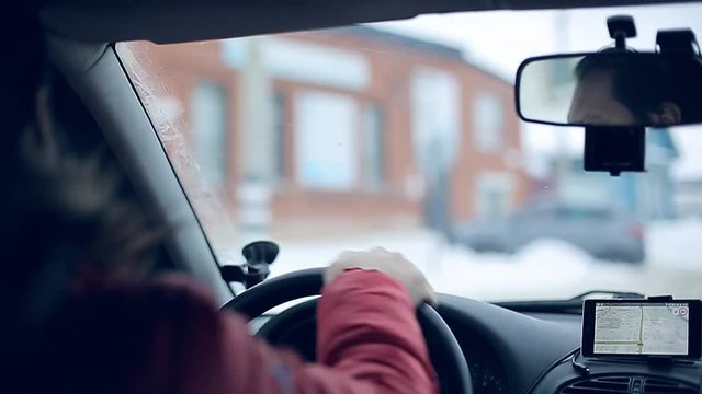 A man gets into the car and turns on the navigator on the smartphone