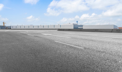 Road asphalt pavement and modern factory warehouse..