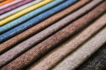 Colorful and bright fabric samples of furniture and clothing upholstery. Close-up of a palette of textile abstract stripes of different colors