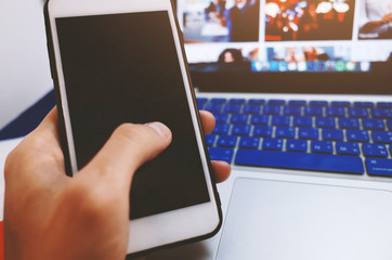 Man holding mobile phone with blank black screen in office