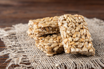 Sunflower seed kozinaki on dark wooden background. Sweet bars with seeds and caramel.