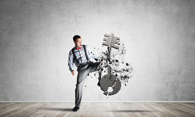 Breaking through access concept with man in room crashing concrete key