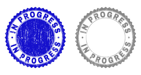 Grunge IN PROGRESS stamp seals isolated on a white background. Rosette seals with grunge texture in blue and grey colors. Vector rubber watermark of IN PROGRESS tag inside round rosette.