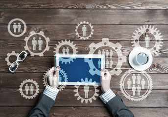 Concept of teamworking and connection with gears mechanism and tablet pc