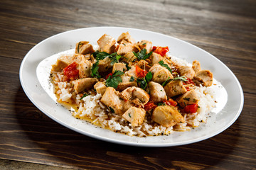 Grilled meat, white rice and vegetables on wooden table