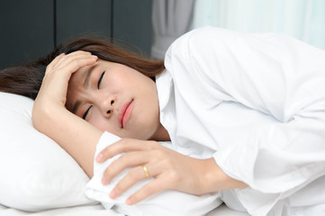 Asian woman headache on white bed,Asian women are suffering from migraines,Asian women are suffering from influenza
