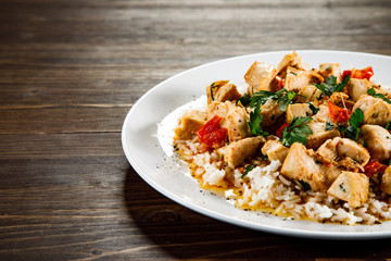 Grilled meat, white rice and vegetables on wooden table
