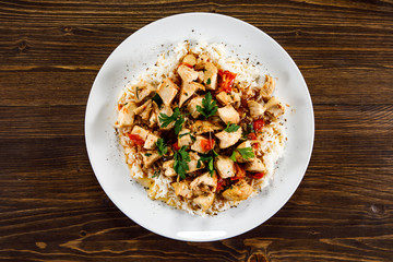 Grilled meat, white rice and vegetables on wooden table