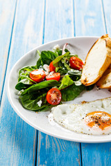 Breakfast - fried egg, toasts and vegetable salad