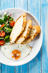 Breakfast - fried egg, toasts and vegetable salad