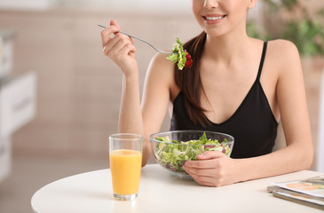 Young woman in fitness clothes having healthy breakfast at home, closeup